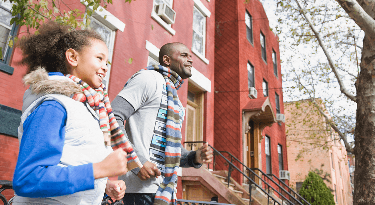 A group of children run across a field with a kite