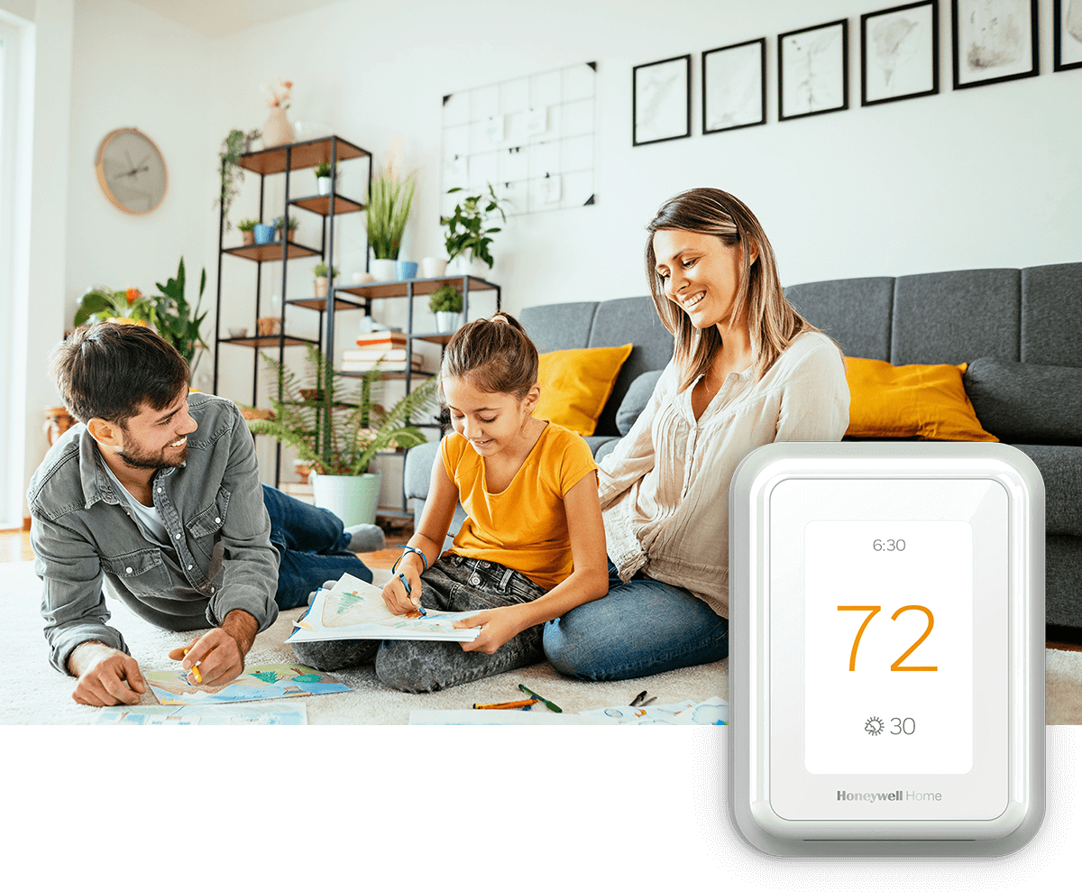A young family shares time together in a bright room with plants and a sofa; a thermostat image is in the foreground