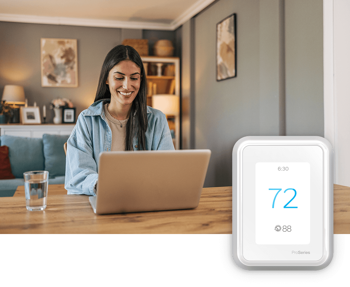 A smiling couple sit on the floor with their dog; a thermostat image is in the foreground