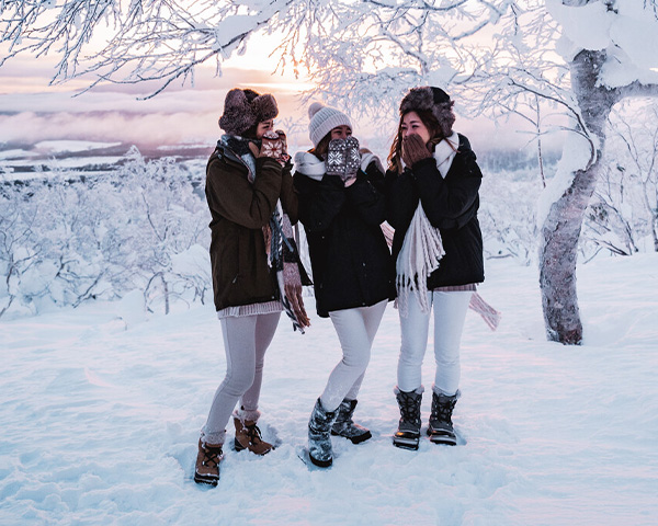 A trio of girls are enjoying the snow together.