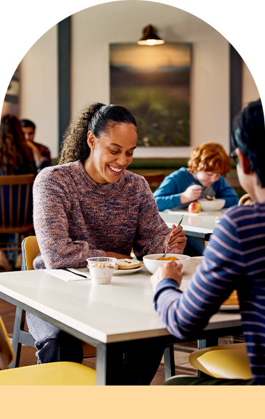 A woman is eating breakfast in the hotel cafeteria.