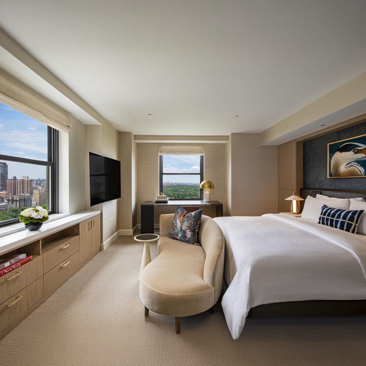 A family relaxes together on a bed in a bright, elegant seaside hotel room with a peaceful ocean view.