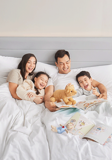 Lifestyle image of a family reading in bed.