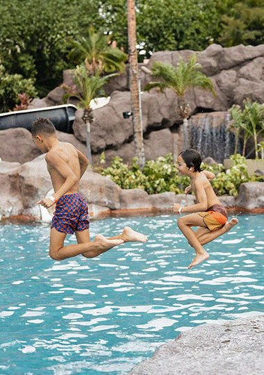 Lifestyle image of two kids jumping into the pool.