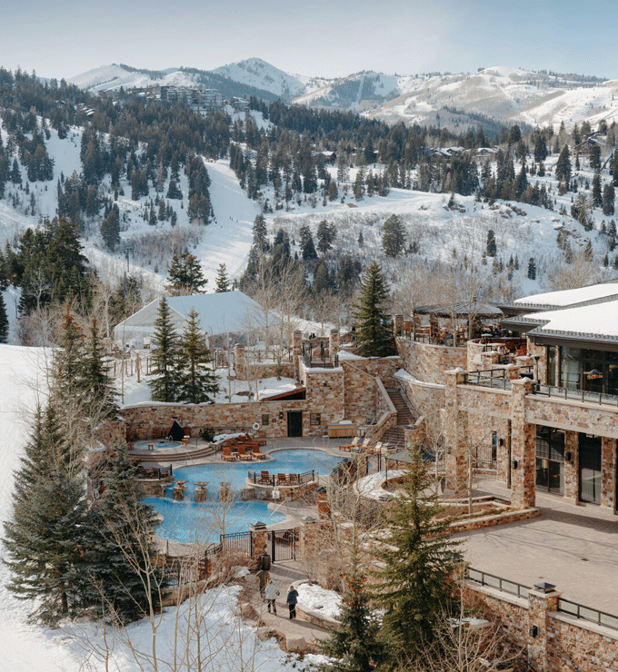 Elegant hotel lobby with multiple orange couches and a chandelier.