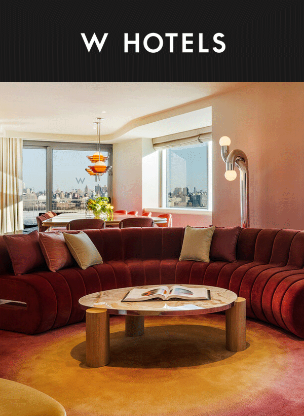 Bright red modern couch in a stylish hotel room overlooking NYC.