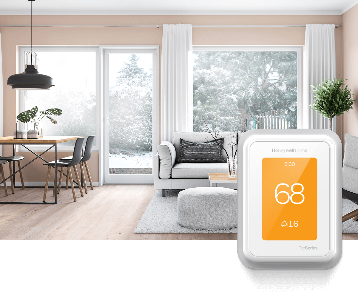 A bright, modern living room features large windows that reveal a snowy scene outdoors. In the foreground, a Honeywell Home thermostat shows 70 degrees.