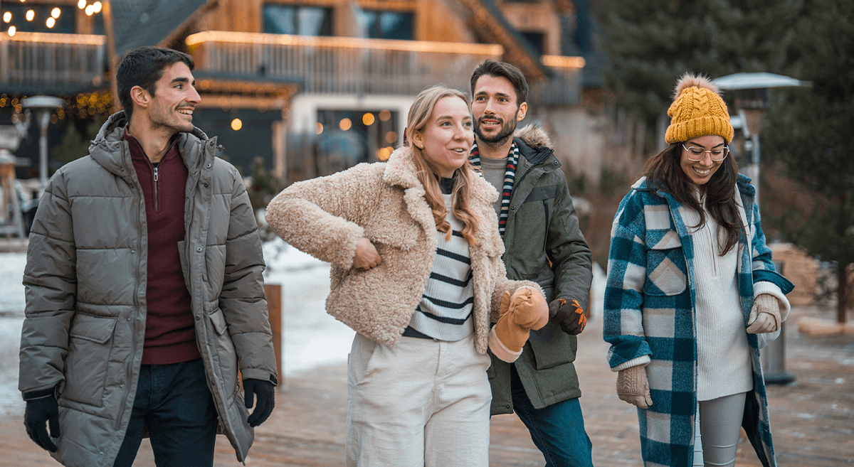 A group of friends wearing winter attire enjoy a chilly day together.