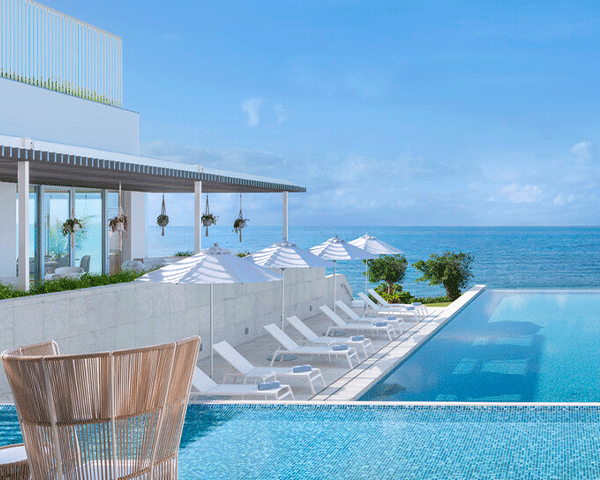 View of pool and ocean at Japanese hotel.