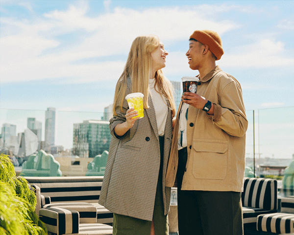 Young couple holding Starbucks drinks.