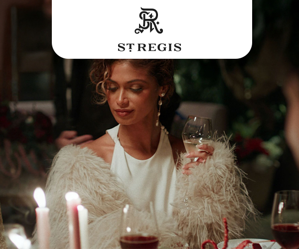 Woman in elegant clothes enjoying a glass of white wine at a celebratory dinner.