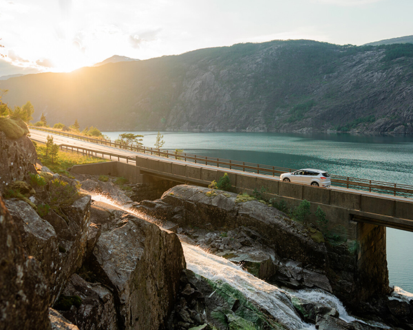 A man smiling while driving his rental car.