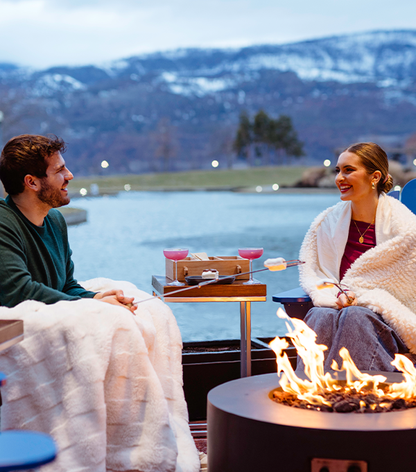 A young couple enjoys some smores by the bonfire.