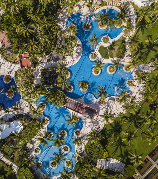 Animated GIF of an aerial view of hotel pool and kayaks on a beach.