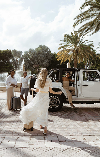 Friends are getting ready to go on an adventure as they gather around their rental car.