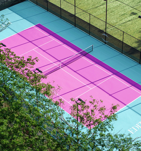 Animated GIF of a bright pink tennis court and a beach with turquoise waters.